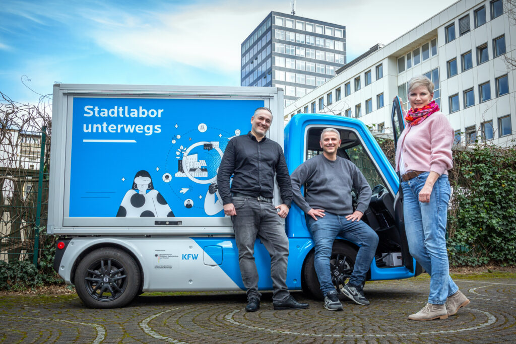 Transporter mit Smart-City-Design, Menschen sitzen davor.