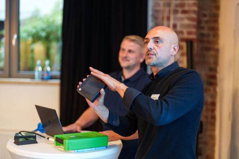 Zwei Referenten diskutieren bei einer Veranstaltung vor Publikum.