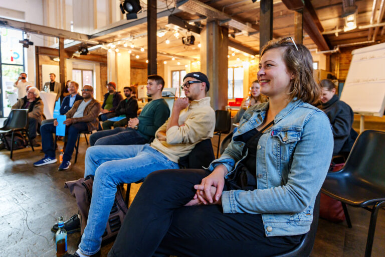 Menschen in einem modernen Veranstaltungsraum bei einem Austausch.