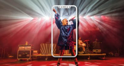 Person bei Live-Auftritt, dargestellt in einem Smartphone-Rahmen.